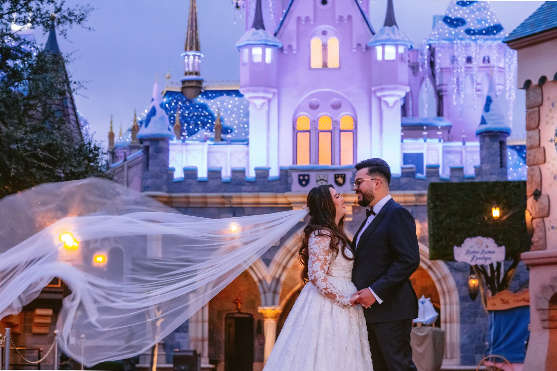 Disneyland wedding couple in front of Sleeping Beauty Castle at twilight
